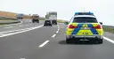 Niemiecki radiowóz na autostradzie, jadący za innymi pojazdami.