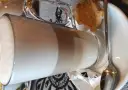 Kawa latte w szklance, obok ciasteczko i cukier. Idealna na przerwę w karczmie u wróbla menu.