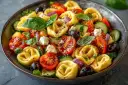Sałatka z tortellini, pomidorkami, ogórkiem, fetą i oliwkami.