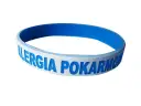 Niebieska opaska na ręce z napisem "ALERGIA POKARMOWA" informuje o problemach z jedzeniem.