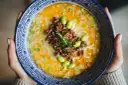 Miseczka tantanmen z mielonym mięsem, edamame i szczypiorkiem.
