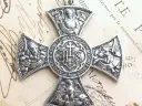Srebrny krzyż z symbolami ewangelistów: lew (św. Marek), anioł (św. Mateusz), wół (św. Łukasz) i orzeł (św. Jan).