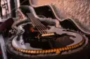 Schwarze Gitarre mit Fell ausgekleidetem Koffer.