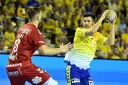 Piłkarz Aalborg Handball w żółtej koszulce rzuca piłkę, obok zawodnik w czerwonej.