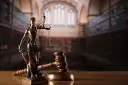 Temida z wagą i mieczem, obok młotka sędziowskiego. Symbol sprawiedliwości, rozstrzygania sporów, w tym służebności mieszkania.