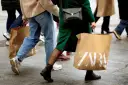Ludzie idący z torbami ZARA. Może to zakupy, a może zwroty.