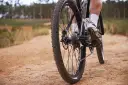Noga rowerzysty na pedale, jazda po piaszczystej ścieżce. Świetny sposób, jak poprawić kondycję.
