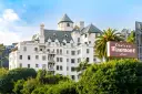 Chateau Marmont, miejsce, gdzie może mieszkać Keanu Reeves, to biały hotel z zielonym dachem i palmami.