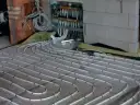 Instalacja podłogówki w trakcie prac. Sprawdź, jaka jest podłogówka cena za m2 robocizny.