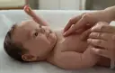 Delikatna pielęgnacja 3 miesięcznego dziecka. Krem na jego klatce piersiowej.