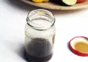 Słoik z domowym sosem balsamicznym i otwartą czerwoną zakrętką.