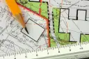 Ołówek i linijka na mapie geodezyjnej. Detale planu pomagają zrozumieć, jak sprawdzić położenie działki i jej wymiary.