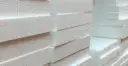 Stos białych płyt styropianowych EPS, gotowych do izolacji.