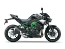 Czarny motocykl Kawasaki Z900 z zielonym stelażem i akcentami. Potężna maszyna gotowa na przygodę.