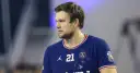 Piłkarz ręczny PSG z numerem 21 na koszulce, skupiony na grze.