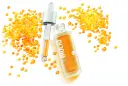 BiolIQ intensywne serum rewitalizujące w buteleczce z pipetą, otoczone kropelkami o pomarańczowym odcieniu.
