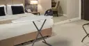 Deska do prasowania z żelazkiem na łóżku w hotelowym pokoju.