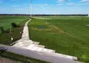 Teren budowy farmy wiatrowej z tymczasową drogą z płyt betonowych. Tłuczeń na drodze ułatwia dojazd ciężkiego sprzętu.