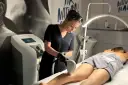 Profesjonalistka wykonuje zabieg depilacji laserowej nogi. To najlepszy laser do depilacji, zapewniający gładkość skóry.