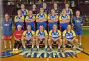 Drużyna SPR Chrobry Głogów pozuje do zdjęcia. Zawodnicy w żółto-niebieskich strojach sportowych, trenerzy i jedna kobieta.