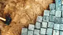 Układanie kostki brukowej na podsypce piaskowo cementowej. Młotek gumowy czeka na użycie.