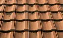 Czerwona dachówka ceramiczna, lekko porośnięta mchem. Sprawdź aktualną dachówka ceramiczna cena za m2.