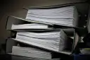 Stosy dokumentów w segregatorach, gotowe do złożenia jako list motywacyjny do urzędu.