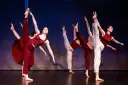 Tancerze wykonują dynamiczny jazz dance, unosząc nogi w powietrze.