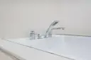 Elegancka bateria wannowa jednootworowa z chromowanymi elementami i słuchawką prysznicową, idealna do nowoczesnej łazienki.