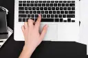 Dłoń naciska klawisz "C" na klawiaturze laptopa, co może być przyczyną, dlaczego nie działa klawiatura w laptopie.