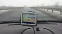 Nawigacja TomTom na desce rozdzielczej samochodu podczas jazdy w mglisty dzień.