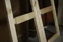 Drewniana konstrukcja, która może posłużyć do nauki, jak zrobić futrynę drewnianą. Elementy są połączone w narożnikach.