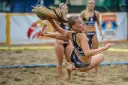 Zawodniczka w skoku po piłkę podczas meczu piłki ręcznej plażowej.