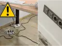 Ostrzeżenie przed bałaganem kabli pod biurkiem. Po prawej stronie widać estetyczną, nowoczesną instalację elektryczną.