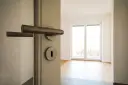 Otwarcie drzwi do pustego mieszkania. Zastanawiasz się, ile kosztuje kawalerka w Niemczech?