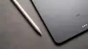Apple Pencil liegt neben einem iPad mit drei leuchtenden Punkten.