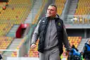 Mężczyzna w kamizelce Jagiellonii, być może omawia nowe jagiellonia transfery na tle pustych trybun stadionu.