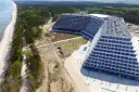 Ogromny, tarasowy hotel nad morzem, prawdopodobnie największy hotel nad morzem, otoczony lasem i plażą.