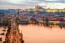 Zachód słońca nad Pragą, tłumy na Moście Karola. Czy do Czech trzeba mieć paszport? Nie, wystarczy dowód osobisty.