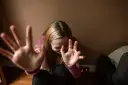 Dziewczyna z rękami przed twarzą, wyrażająca niepokój.