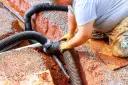 Instalator łączy rury odprowadzające wodę do budowanej studni chłonnej.