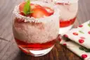 Pyszny deser: pudding z tapioki z truskawkami i wiórkami kokosowymi w szklance, ozdobiony miętą.