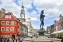 Rynek w Poznaniu z fontanną i kolorowymi kamienicami.