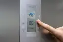 Palec naciska przycisk "super" na panelu lodówki no frost. Wyświetlacz pokazuje -26°C i 06°C.