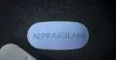 Niebieska tabletka z napisem ALPRAZOLAM. Zastanawiasz się, ile godzin działa afobam?