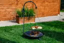 Grill trójnóg z paleniskiem i rusztem, na którym znajdują się kiełbaski, pieczywo i warzywa.