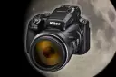 Czarny aparat Nikon Coolpix P1000 z żółtym obiektywem na tle księżyca. Idealny do fotografowania odległych obiektów.