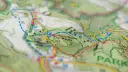 Fragment mapy turystycznej z zaznaczonymi szlakami. Czerwony szlak oznacza główną trasę pieszą, idealną do odkrywania uroków przyrody.