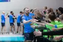 Gracz MKS Wieluń w niebieskiej koszulce z numerem 1 daje "piątki" młodym kibicom.