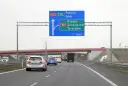 Autostradą A2 w kierunku Poznania i Łodzi. Znak informuje o minimalnej prędkości na autostradzie i zjeździe na Grójec, Sochaczew, Żyrardów za 500 m.